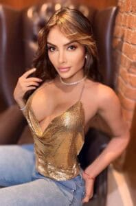 Nina sitting in a gold glittery vest