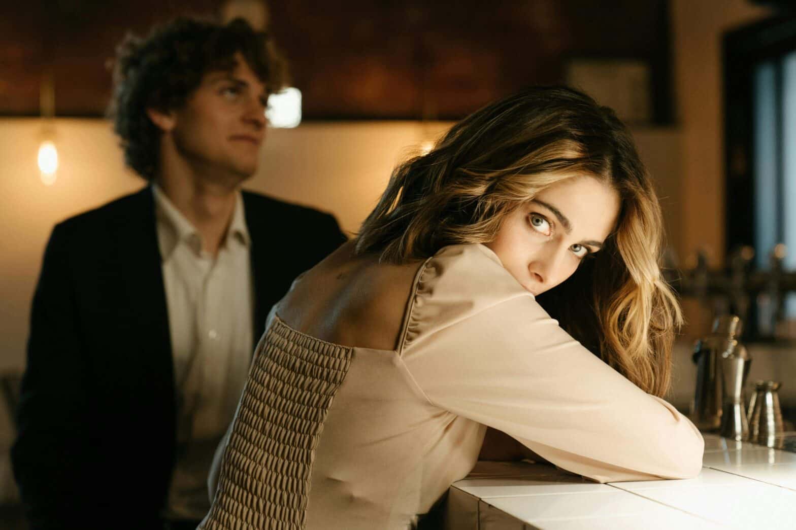 an escort on a date with a client at a bar looking at us over her shoulder as he looks away