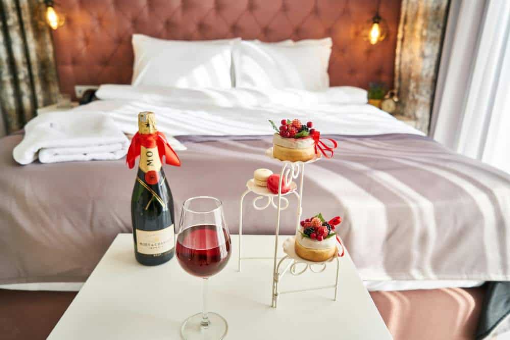A luxury hotel room with wine and treats