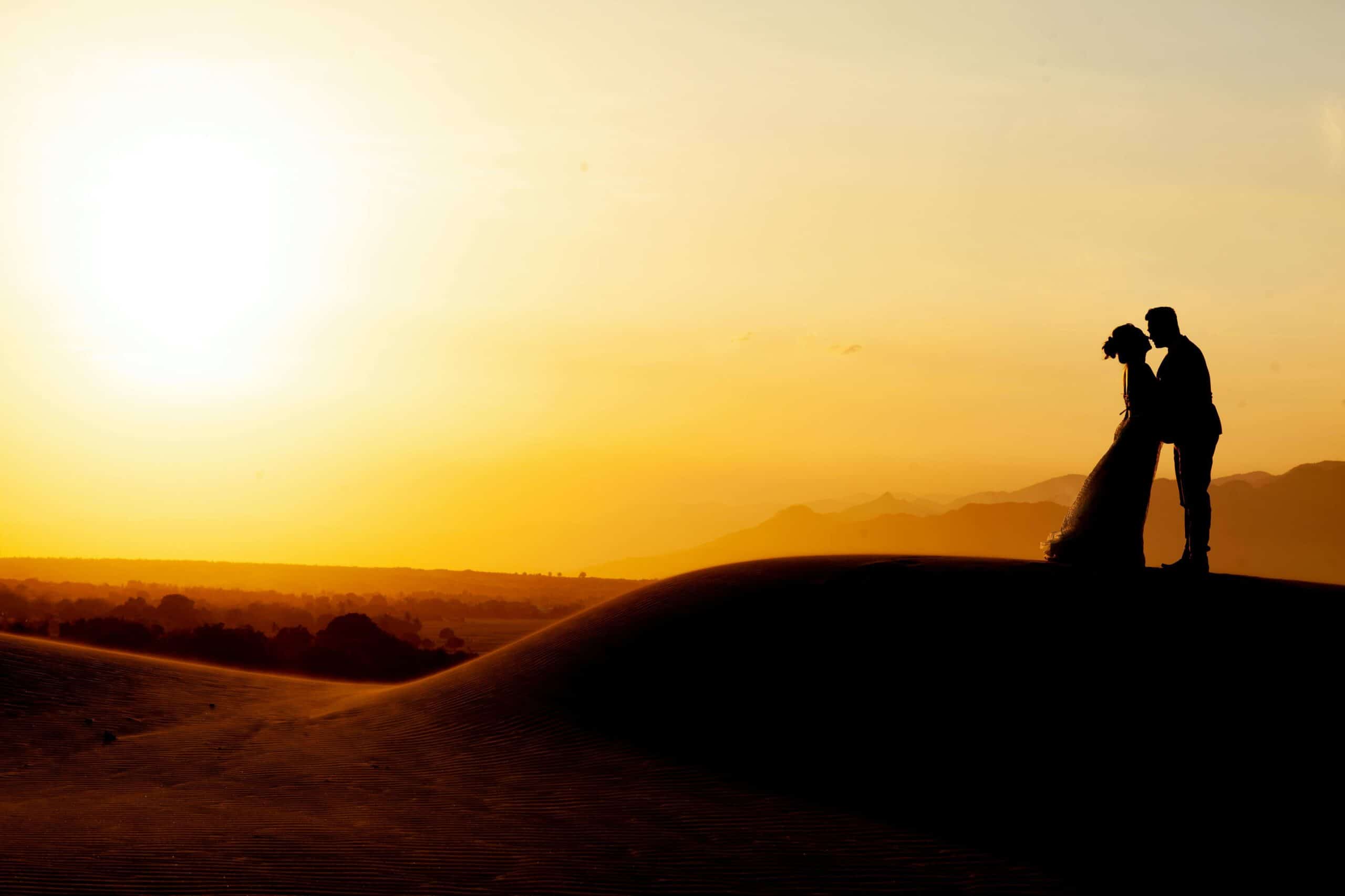 a couple in the desert at sunset
