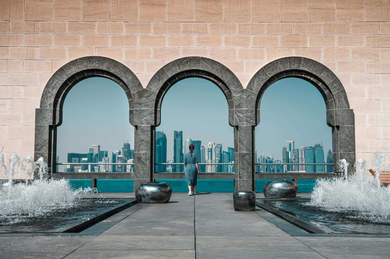 a building with stone arches with a view of a city in Qatar