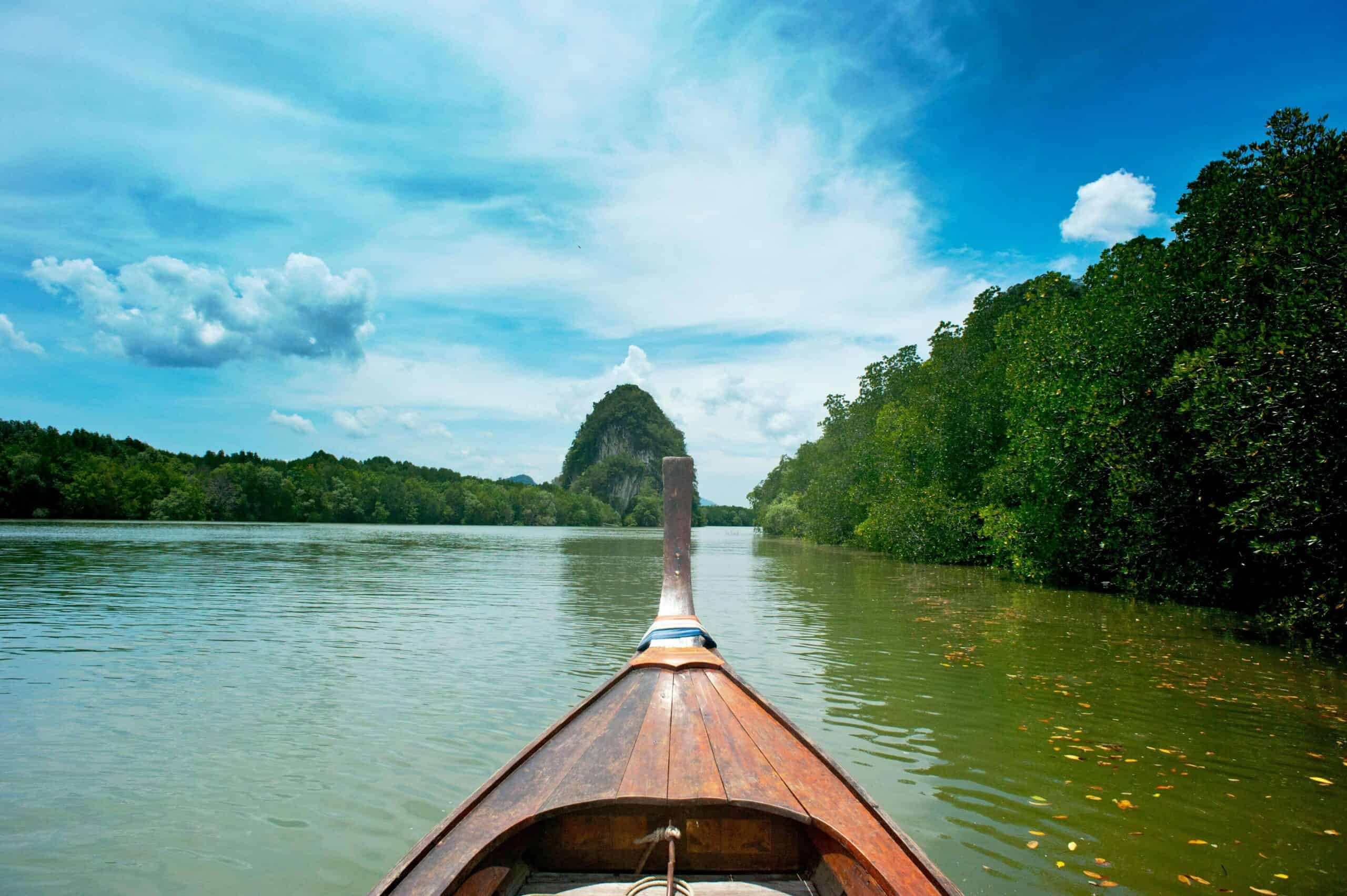 a kayak boat on a rivver with trees lining it