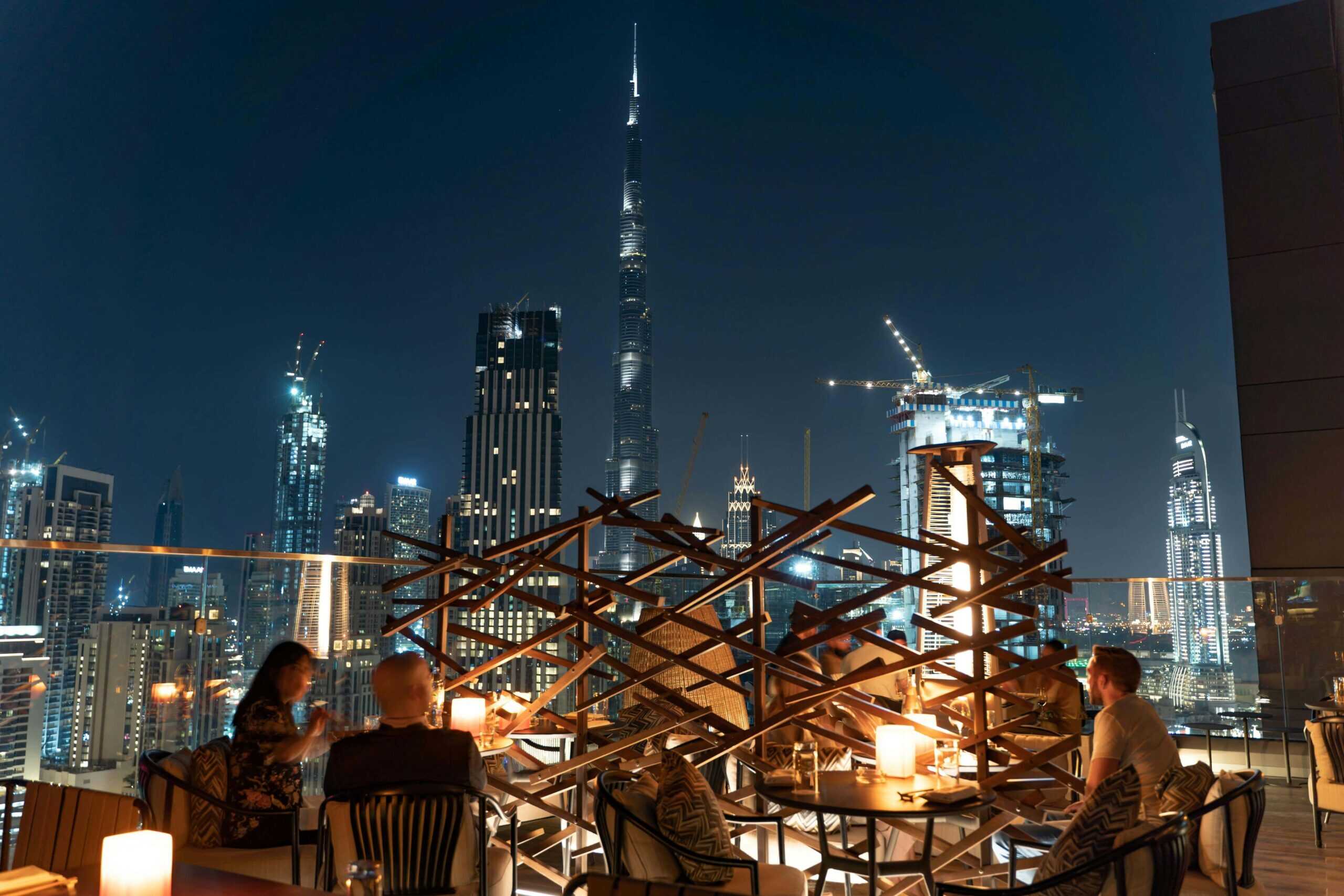 a rooftop bar with a view of Dubai buildings