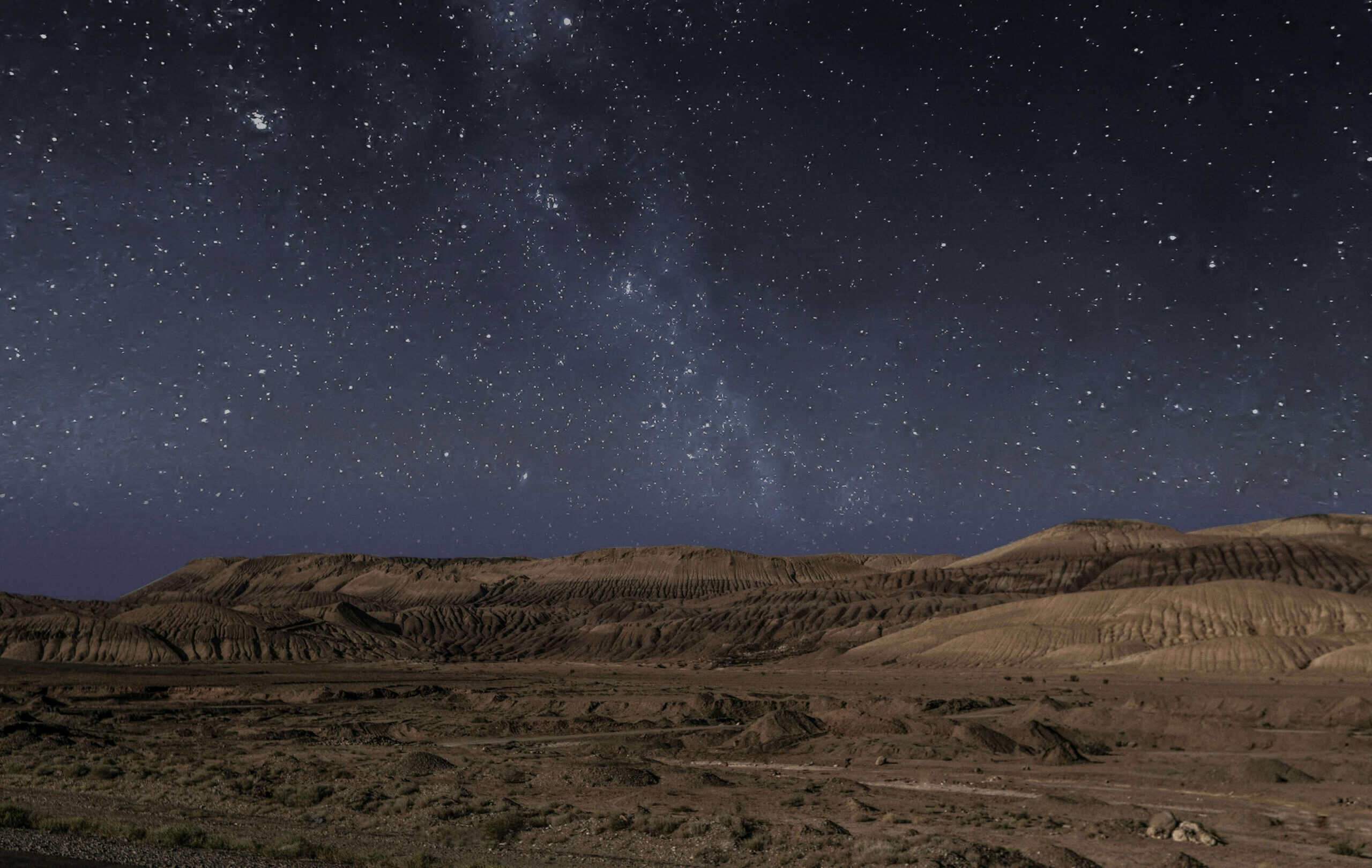 a starry sky above a desert in Doha
