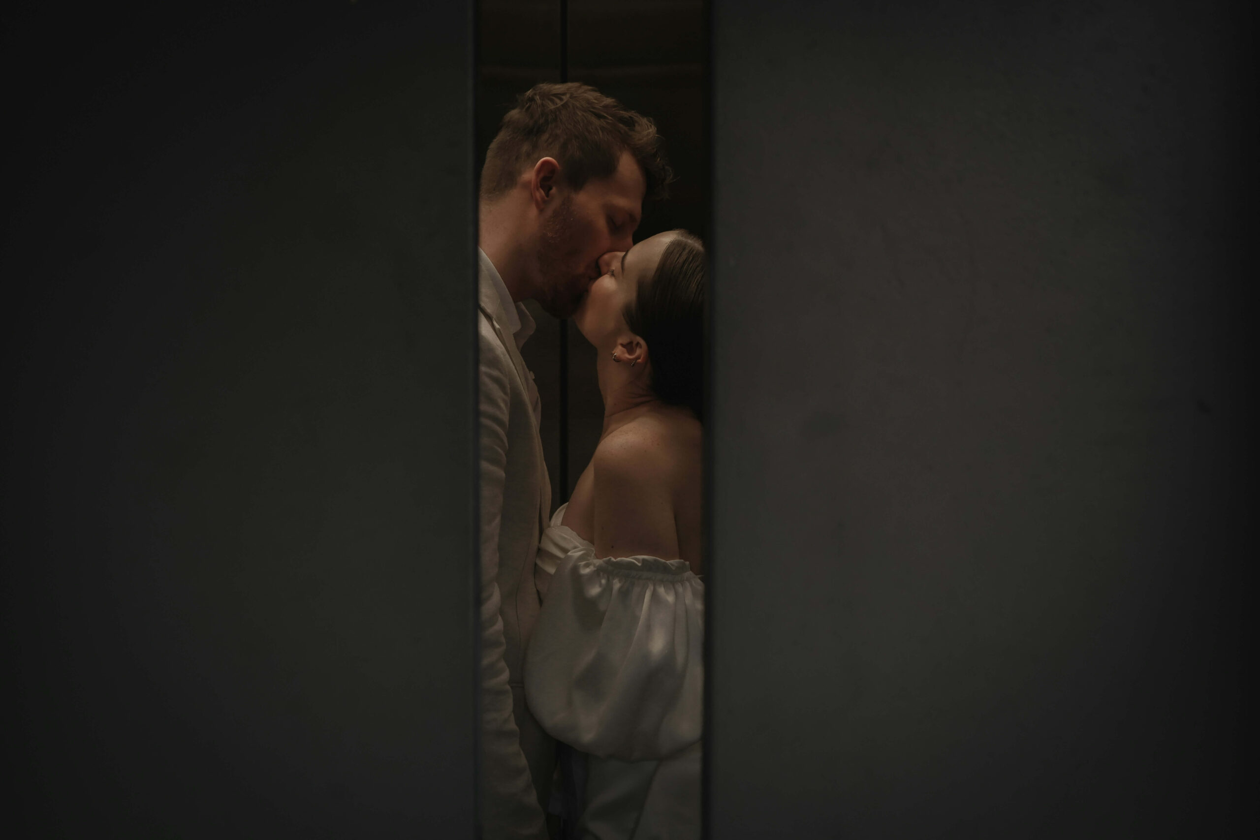 an escort and her client kissing with the door closing
